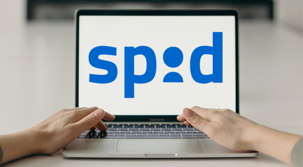 Immagine raffigurante mani che scrivono su tastiera pc portatile e schermo con scritta "SPID"